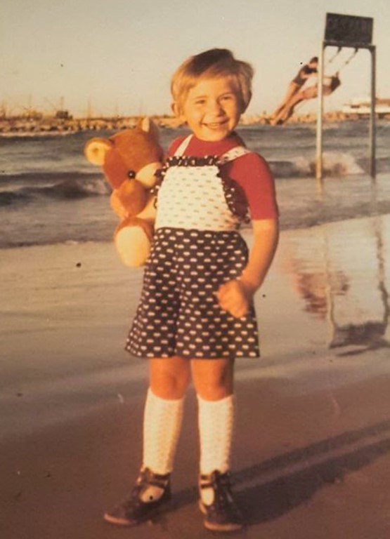 Bambina con orsetto di peluche sulla spiaggia del Lido